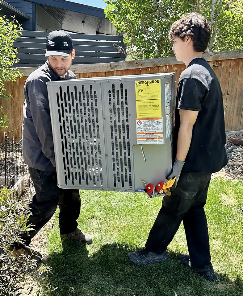 Team carrying an ac unit in Denver, CO.