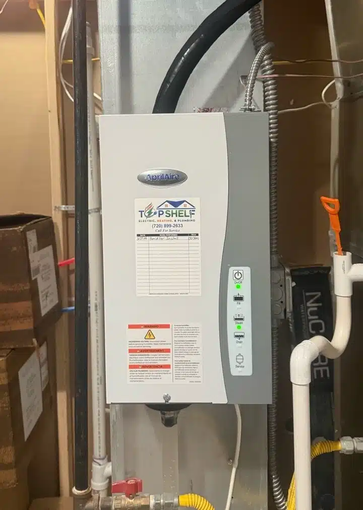 AprilAire steam humidifier with green indicator light installed on a furnace system by Top Shelf in Denver, CO