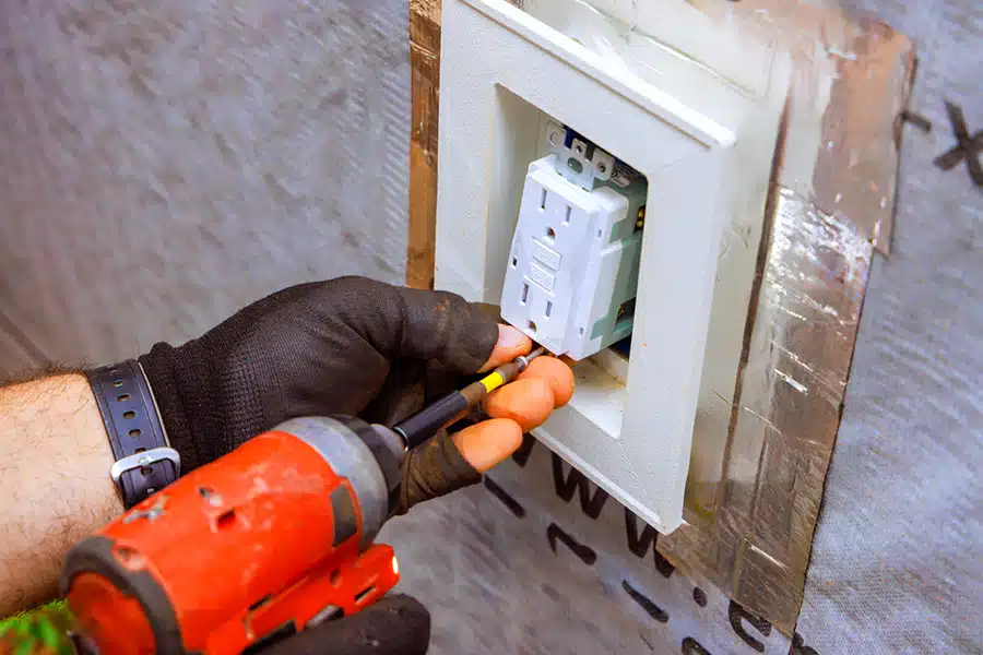 Electrician installing an outlet in residential home